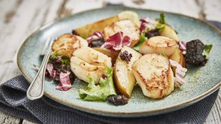 Warm Scallop, Black Pudding and Pear Salad served on a blue plate