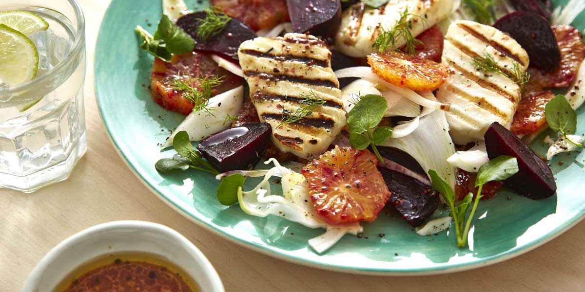 Blood Orange, Beetroot and Griddled Halloumi Salad served on a blue plate and sprinkled with parsley and dill