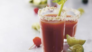 The Perfect Bloody Mary served in a glass, garnished with salt and pepper and a celery stick