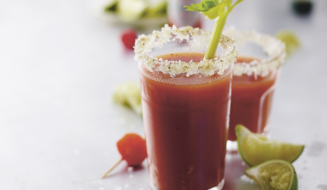 The Perfect Bloody Mary served in a glass, garnished with salt and pepper and a celery stick