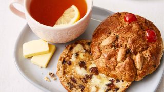 Booths Yorkshire Buns served toasted on a plate with butter and a cup of earl grey tea