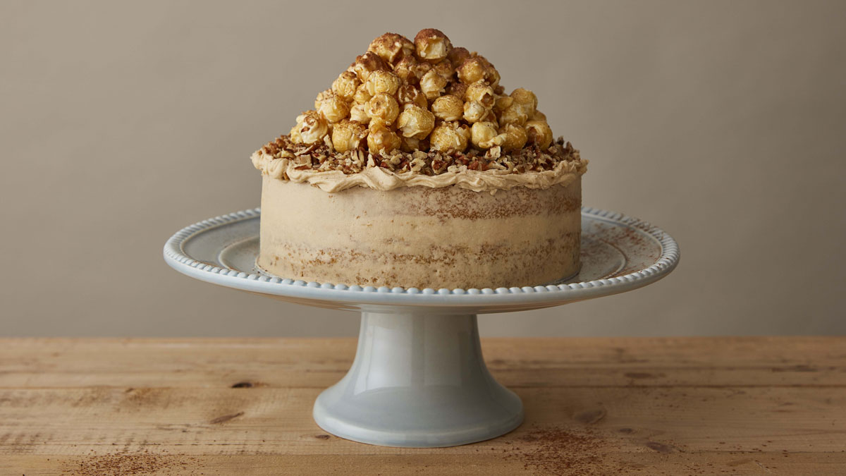 Cappucino Cake topped with popcorn served on a white cake dish