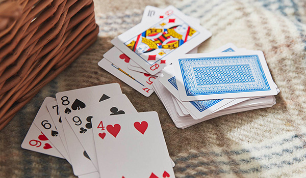 A deck of cards spread out of the picnic blanket.