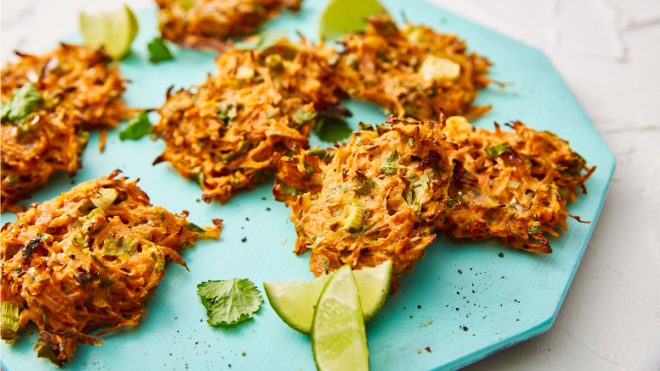 Carrot Fritters served on a blue plate with lime wedges