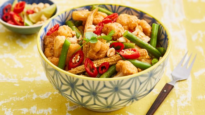 Quick Thai Red Cauliflower Curry served in a patterned bowl topped with fresh red chillies