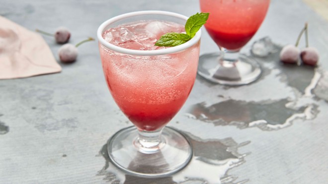 Fresh Cherry Lemonade served in glasses, with ice and a sprig of mint
