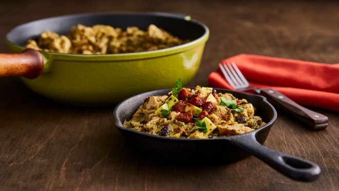 Chicken Chilli with Avocado and Chorizo served in a pan and a small skillet on a wooden table