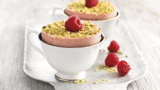 Chilled Raspberry Souffle served in white teacups with crushed pistachio