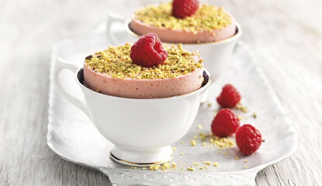 Chilled Raspberry Souffle served in white teacups with crushed pistachio