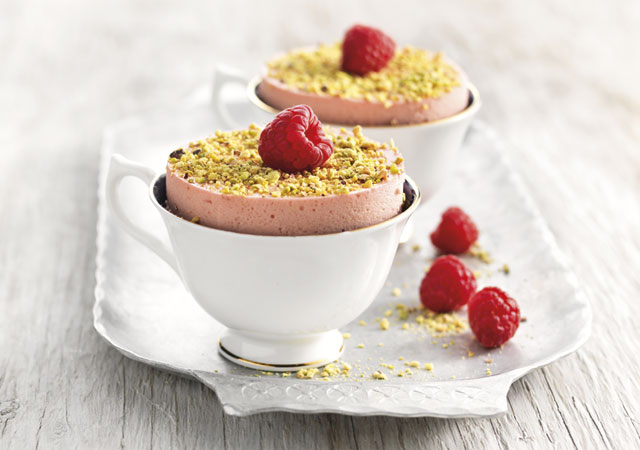 Chilled Raspberry Souffle served in white teacups with crushed pistachio