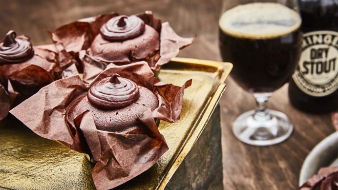 Chocolate and Ale Muffins served on a gold tray, with a bottle and glass of stout in the background