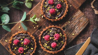 Chocolate and Honey Tarts topped with fresh raspberries and crushed pistachios