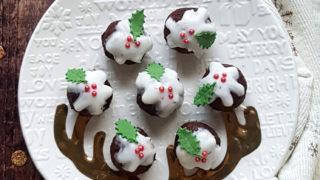 Chocolate Truffles served on a white festive plate, with the truffles decorated with white icing to look like Christmas puddings