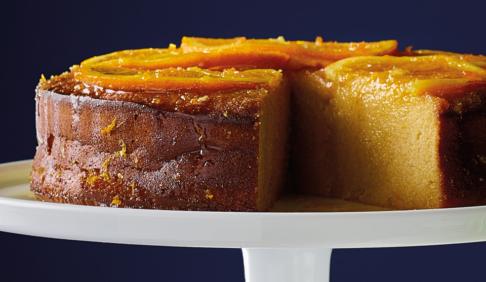 Gluten-Free Zesty Orange Polenta Cake served on a white dish with a slice removed