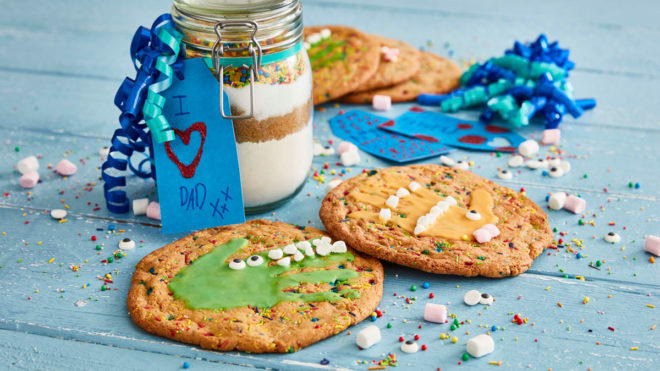 Decorated cookies in front of a jar of dry ingredients