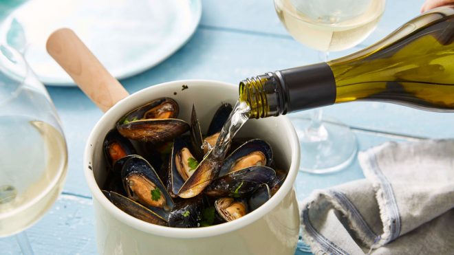 Wine bottle Pouring White Wine into a pot of mussels