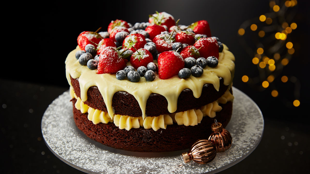 Snowberry Cake, served on a grey cake dish, dusted with icing sugar