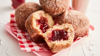 Breakfast Doughnut Muffins served on gingham paper with one opened to see the filling