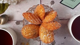 Earl Grey Madelines served in a glass dish and dusted with icing sugar