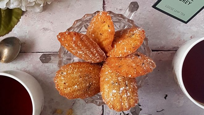 Earl Grey Madelines served in a glass dish and dusted with icing sugar