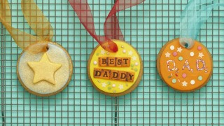 Father's Day Medals decorated and threaded with ribbon placed on a drying rack