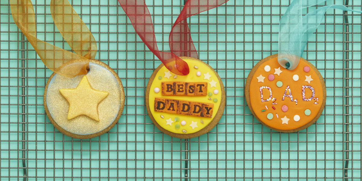 Father's Day Medals decorated and threaded with ribbon placed on a drying rack