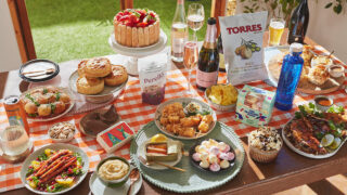A spring garden party table spread with a variety of food and drinks