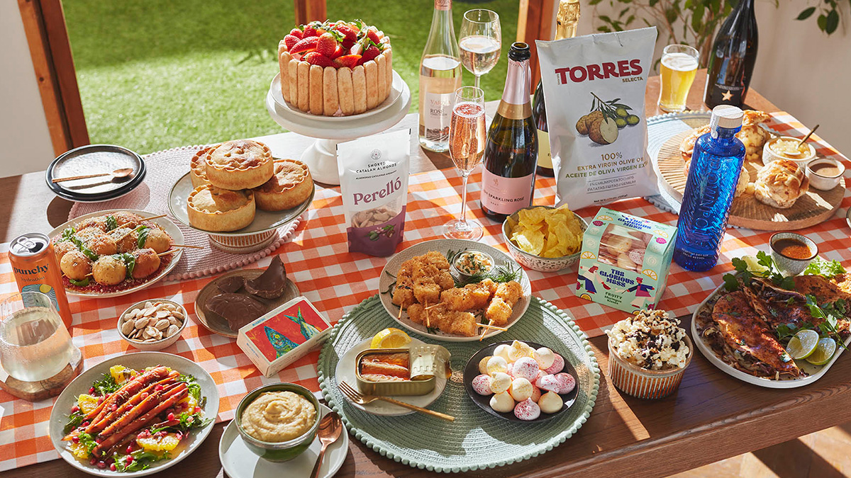 A spring garden party table spread with a variety of food and drinks