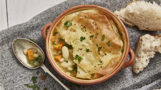 Vegetable and Pearl Barley Filo Pot Pies served in individual dishes with part of the topping removed to reveal the filling