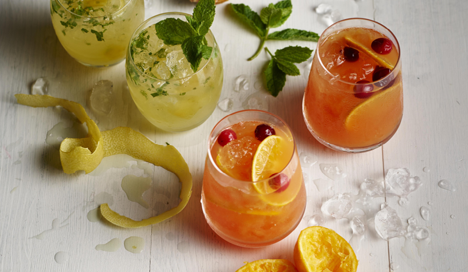 Fresh and Fruity Non Alcoholic Cocktails served in four glasses surrounded by fruit peel and crushed ice