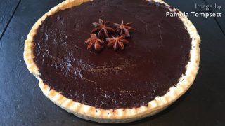 Spiced Chocolate Tart topped with star anise served on a slate