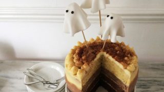 Malted Ombre Ghost Cake served on a white dish with a slice removed to see the ombre effect inside