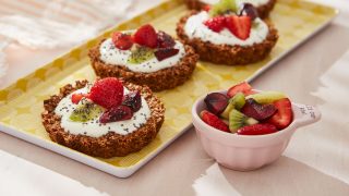 Granola Breakfast Tarts served on a yellow tray next to a bowl of fruit