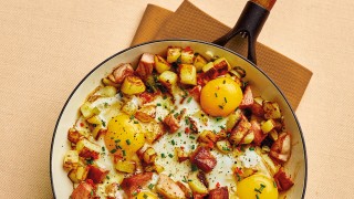 Crusty Ham and Potato Hash topped with chives, served in a pan