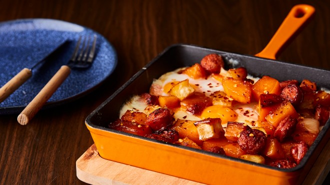 Chorizo and Butternut Squash Hash served in an iron skillet, next to a blue plate