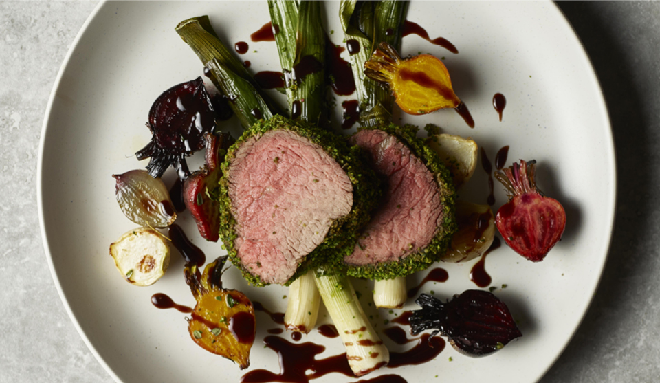 Herb Crusted Filled of Beef served on a white plate with roasted beetroot and red wine sauce