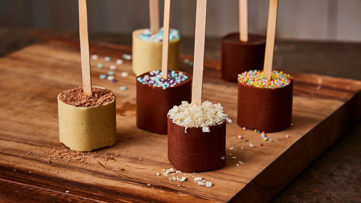 Hot Chocolate Stirrers served on a wooden board with various toppings and decorations