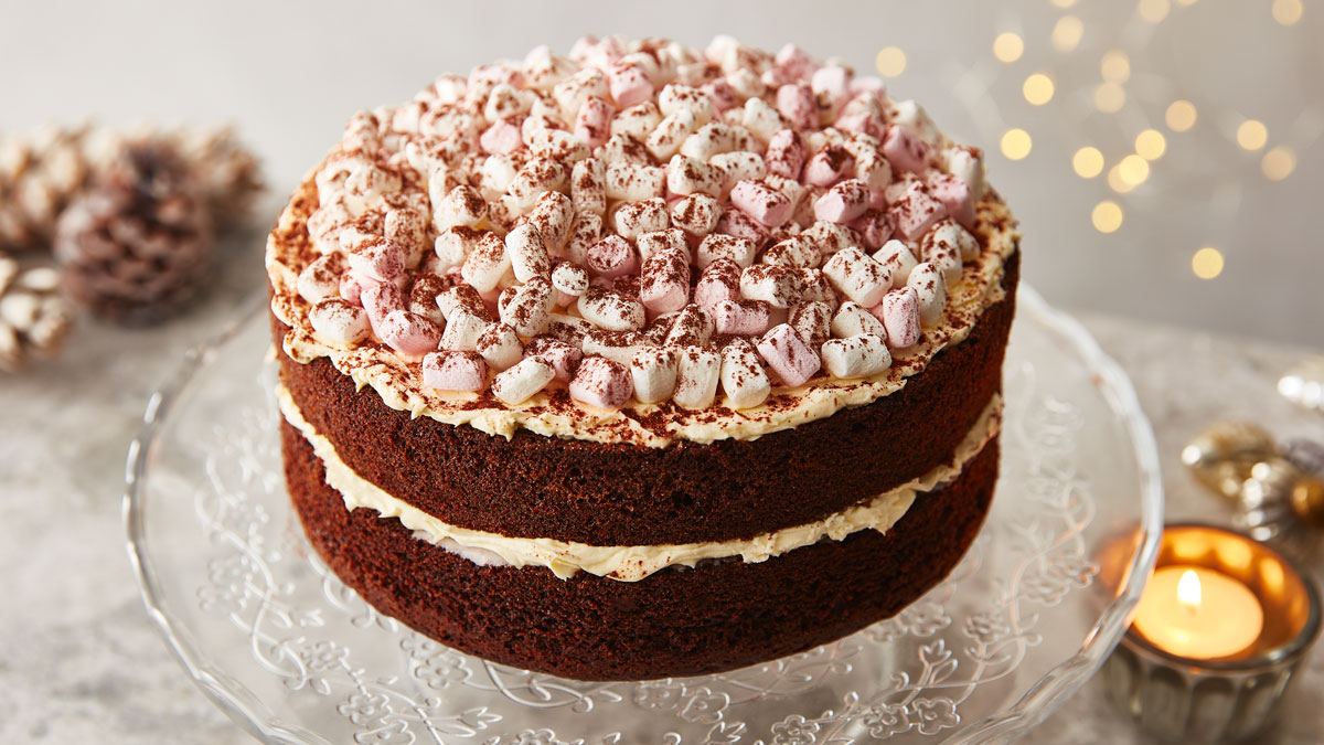 Hot Chocolate Cake with Almond Cream and Marshmallows served on a glass cake dish