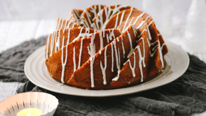 Lemon and Lime Bundt Cake served on a white plate, drizzled with white icing