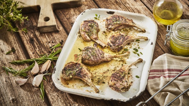 Super Easy Herb Marinated Lamb Chops served on a baking tray with sprigs on rosemary and olive oil