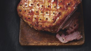Marmalade and Mustard Glazed Christmas Ham carved and served on a wooden board
