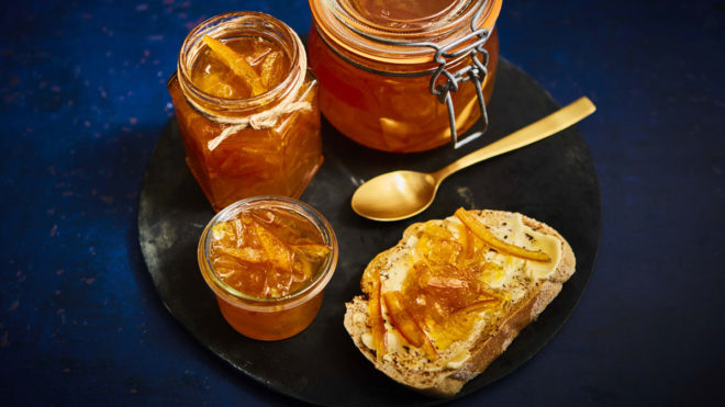 Seville Orange Marmalade with Gin spread on buttered bread and stored in a glass jar