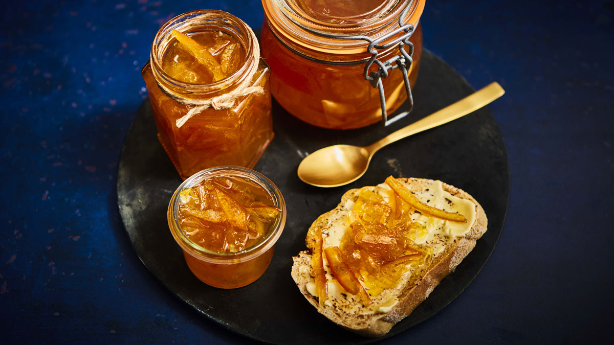 Seville Orange Marmalade with Gin spread on buttered bread and stored in a glass jar