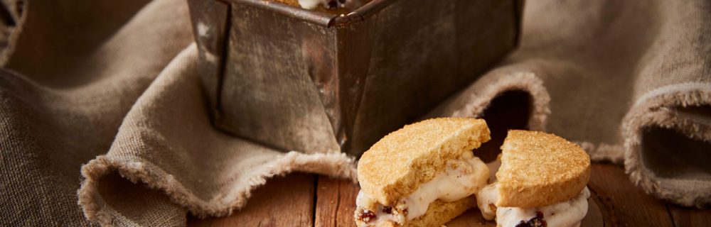 Mince Pie Ice Cream Shortbread Sandwiches served in a baking tin, with one sandwich on a wooden plate