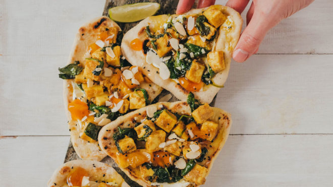 Lightly Spiced Paneer Flatbreads served with a lime wedge on a wooden board