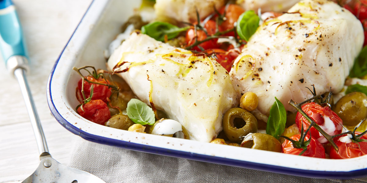 One Pot Cod Supper served in a baking dish with vine tomatoes and olives and capers