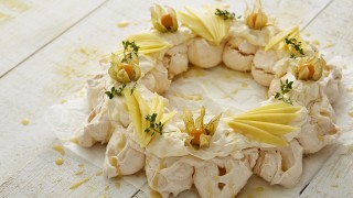 Coconut Meringue Wreath served on baking parchment and drizzled with lemon curd