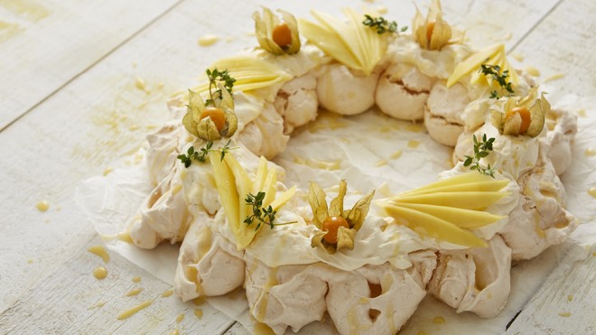 Coconut Meringue Wreath served on baking parchment and drizzled with lemon curd
