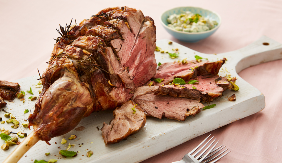 Classic Roast Leg of Lamb, sliced and served on a white serving board