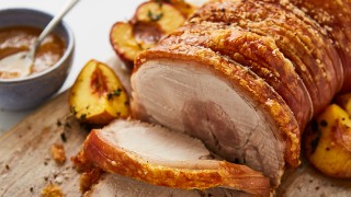 Perfect Roast Pork Loin with Crackling served sliced on a wooden board